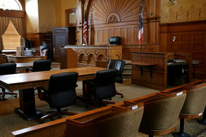 A courtroom with chairs, a table and a judge 's bench.